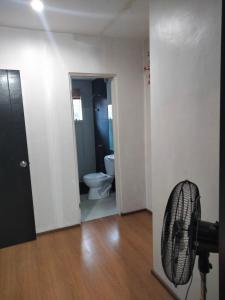 ein Bad mit WC und einen Ventilator in einem Zimmer in der Unterkunft Bambu Estate transient house in Mintal