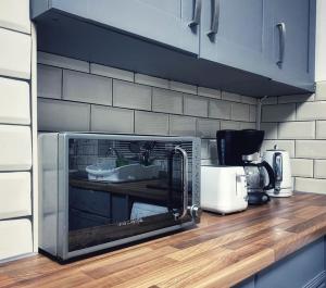 um micro-ondas sentado num balcão numa cozinha em Urban Music Style Townhouse in Swansea city center em Swansea