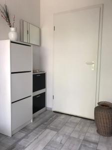 a kitchen with a white refrigerator and a mirror at Ferienwohnung Am Schwanenteich in Norden