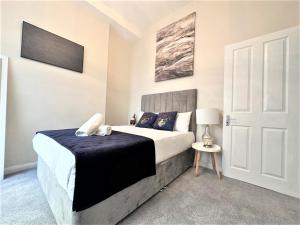布萊頓霍夫的住宿－Mins away from Brighton seafront Central 1 bedroom flat，一间卧室配有一张带蓝色毯子的床