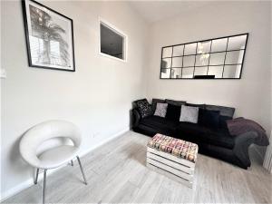 布萊頓霍夫的住宿－Mins away from Brighton seafront Central 1 bedroom flat，客厅配有黑色沙发和椅子