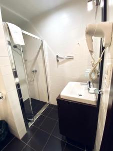 W łazience znajduje się prysznic, biała umywalka i prysznic. w obiekcie Apartman Deluxe Štrbské Pleso w Szczyrbskim Plesie