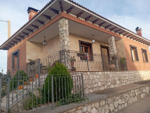 uma casa com uma varanda e uma cerca em Casa Los Lagares em Peral de Arlanza