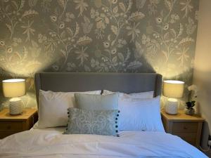 a bedroom with a bed with two night stands with two lamps at Pedlars Rest in Swaffham