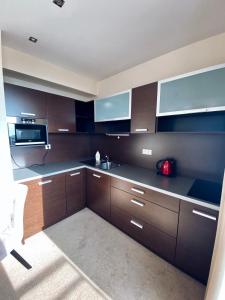 a large kitchen with brown cabinets and a sink at Apartman Deluxe Štrbské Pleso in Vysoke Tatry - Strbske Pleso