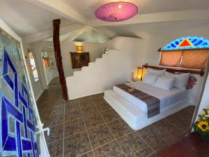 Bambuddha Centro Holistico في Barra Vieja: غرفة نوم بسرير في غرفة بها درج