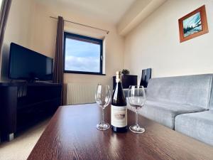 a living room with two wine glasses on a table at Apartman Deluxe Štrbské Pleso in Štrbské Pleso