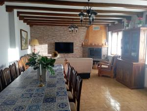 a dining room with a long table and a living room at Casa Los Lagares in Peral de Arlanza