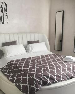 a bedroom with a large bed with a black and white comforter at B&B Universo in Codogno