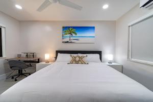 1 dormitorio con 1 cama blanca grande y escritorio en Walnut By The Sea, en Hollywood