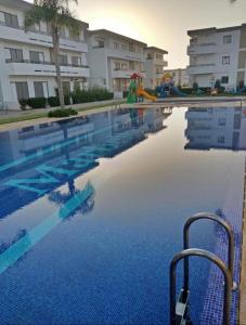 an empty swimming pool with a resort at Mohammédia Marbella beach appartement familliale in Mansouria