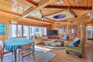 a living room with a table and a tv at Retro Rhinelander Lake Retreat with Fire Pit! in Rhinelander