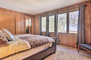 a bedroom with wooden walls and a bed and windows at Retro Rhinelander Lake Retreat with Fire Pit! in Rhinelander