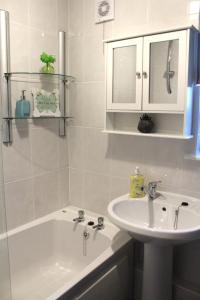 a bathroom with a sink and a bath tub and a sink at PREMIER - Fleming Apartment in Hamilton