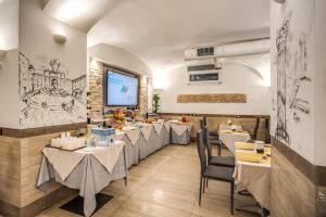 um restaurante com mesas e cadeiras e uma tela de projeção em Hotel Centro Cavour Roma em Roma