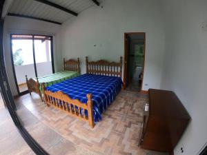 San CarlosにあるFINCA HOTEL CURIBAYの青い掛け布団が敷かれたベッドのある寝室