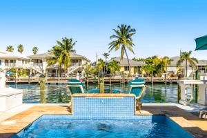 a resort pool with two chairs and a dock at Relaxation Station in Key Colony Beach