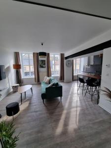 Una sala de estar con un sofá verde y una mesa. en Appartement Jungle- hypercentre -Charleville, en Charleville-Mézières
