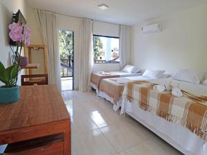 Habitación de hotel con 2 camas y mesa en APARTAMENTOS DO BRUNO, en Arraial d'Ajuda