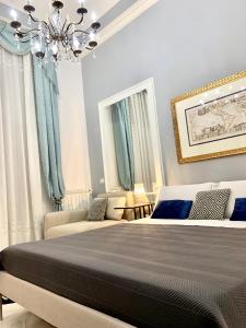 - une chambre avec un lit doté de rideaux bleus et d'un lustre dans l'établissement Casa del corso, à Acireale