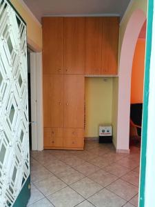 a room with wooden cabinets and a tiled floor at Detached house with a lovely yard 5' walk from Metro Station Agios Dimitrios and METRO MALL in Athens