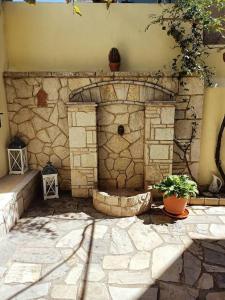 un muro in pietra con fontana in un cortile di Detached house with a lovely yard 5' walk from Metro Station Agios Dimitrios and METRO MALL ad Atene