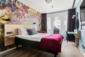 1 dormitorio con 1 cama grande y pared colorida en Best Western Kom Hotel Stockholm, en Estocolmo