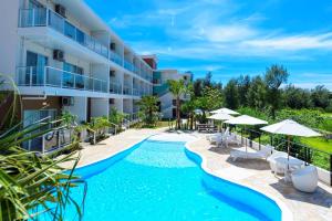 uma imagem de uma piscina de resort com guarda-sóis em Best Western Okinawa Onna Beach em Onna