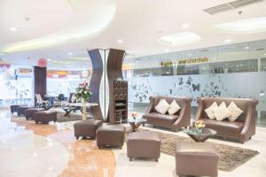 a lobby with couches and chairs in a building at Best Western Papilio Hotel in Surabaya