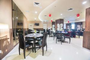 a dining room with tables and chairs in a restaurant at Best Western Papilio Hotel in Surabaya