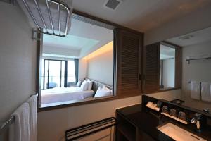 Best Western Okinawa Kouki Beach في ناغُو: حمام مع مرآة كبيرة في غرفة الفندق