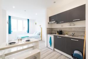 a kitchen with a sink and a bed in a room at Glm Residences 1 in Saint-Quentin