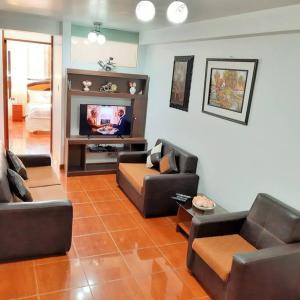 a living room with couches and a flat screen tv at Departamento para 6 personas a 3 minutos del aeropuerto in Cusco