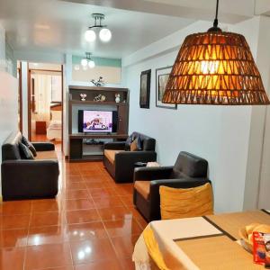 a living room with couches and a flat screen tv at Departamento para 6 personas a 3 minutos del aeropuerto in Cusco