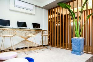 a living room with a desk and a potted plant at SureStay Studio by Best Western Clarkview Angeles City in Angeles