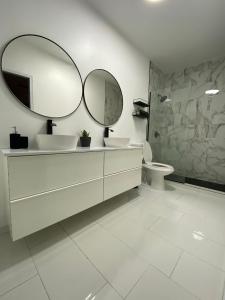 baño con 2 lavabos y espejo grande en Casa Isabela En Cabo Rojo, en Cabo Rojo