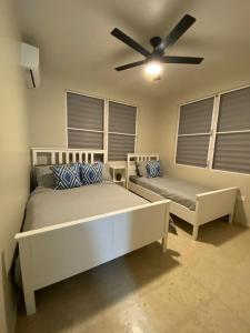 a bedroom with two beds and a ceiling fan at Casa Isabela En Cabo Rojo in Cabo Rojo