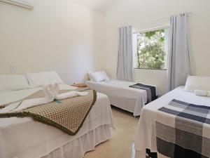 Habitación de hotel con 2 camas y ventana en CASA do BRUNO ARRAIAL D'AJUDA, en Arraial d'Ajuda