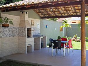 un patio con mesa y sillas bajo una pérgola en CASA do BRUNO ARRAIAL D'AJUDA, en Arraial d'Ajuda