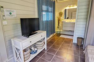 una televisione su un tavolo in un bagno con vasca di Bungalow proche plage a Sainte-Luce