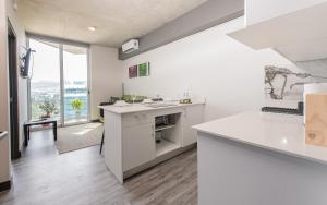 a kitchen with white counters and a large window at San José Apt with Fantastic Views, Parking and Air Conditioning in San José