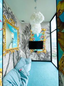 a room with a tv and a wall with a mural at San José Apt with Fantastic Views, Parking and Air Conditioning in San José