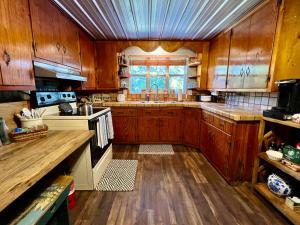 uma cozinha com armários de madeira, um lavatório e um fogão em Quiet Farmhouse close to major theme parks em Ridge Manor