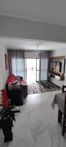 瓜魯雅的住宿－Apartamento Guarujá Astúrias，客厅配有床和桌子