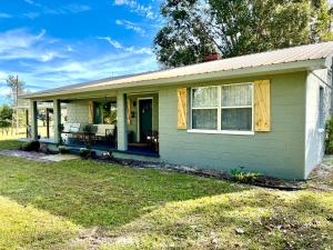 uma pequena casa verde com um alpendre em Quiet Farmhouse close to major theme parks em Ridge Manor