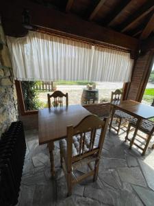 un patio con 2 mesas y sillas y una ventana en Posada La Llosa de Viveda - Adults Only, en Santillana del Mar