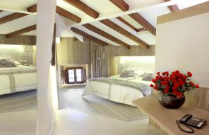プエブラ・デ・サナブリアにあるHotel Las Treixasのベッドルーム1室(ベッド2台付)、テーブルに花瓶1本が備わります。