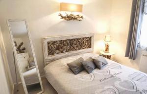 una camera da letto con un letto grande e uno specchio di La Maison Du Bois Flotté a Boulogne-sur-Mer