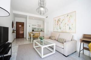 salon z kanapą i stołem w obiekcie Alijar Lux Bormujos con piscina y parking gratis w mieście Bormujos