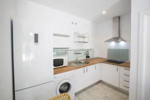 a white kitchen with a sink and a microwave at Alijar Lux Bormujos in Bormujos